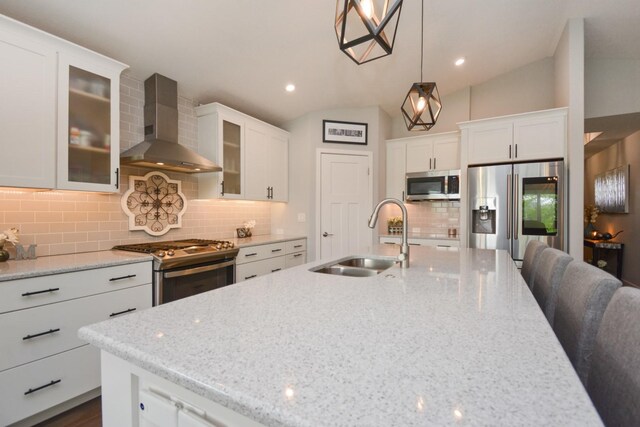 1104 Hershey Rd, Normal, IL 61761 - kitchen featuring wall chimney exhaust hood, stainless steel appliances, decorative backsplash, white cabinetry, and a kitchen island with sink