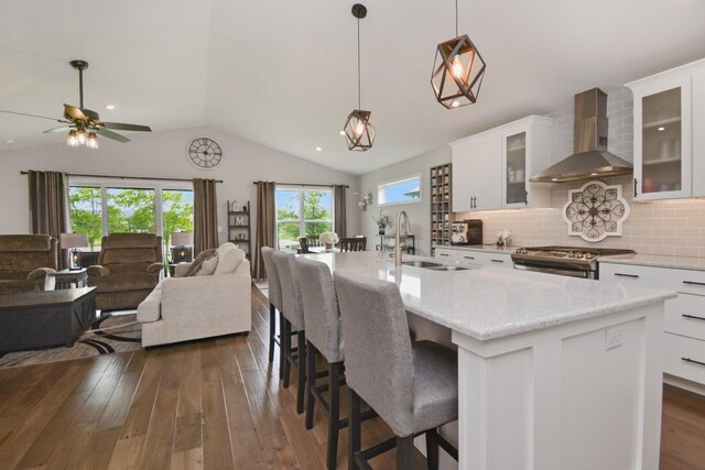 1104 Hershey Rd, Normal, IL 61761 - kitchen with wall chimney range hood, stainless steel range with gas stovetop, vaulted ceiling, dark wood-type flooring, and open floor plan