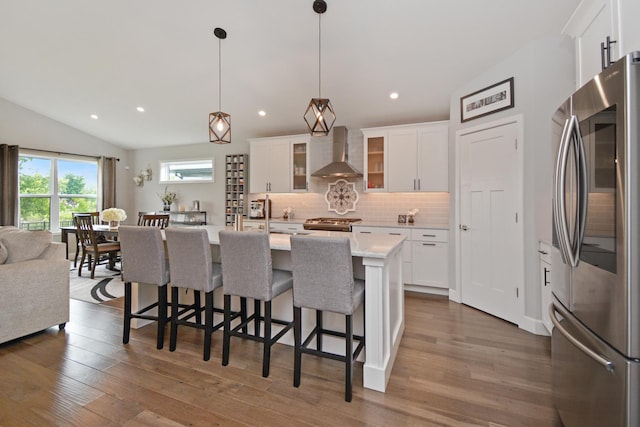 1104 Hershey Rd, Normal, IL 61761 - kitchen featuring stainless steel appliances, wall chimney exhaust hood, decorative backsplash, open floor plan, and white cabinets