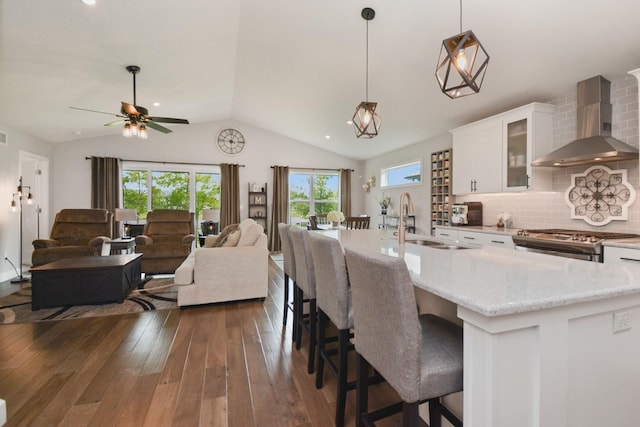 1104 Hershey Rd, Normal, IL 61761 - kitchen with wall chimney exhaust hood, lofted ceiling, stainless steel stove, white cabinets, and dark wood-style flooring