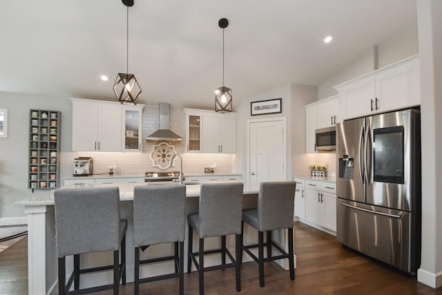 1104 Hershey Rd, Normal, IL 61761 - kitchen featuring appliances with stainless steel finishes, wall chimney exhaust hood, decorative backsplash, a kitchen island with sink, and glass insert cabinets