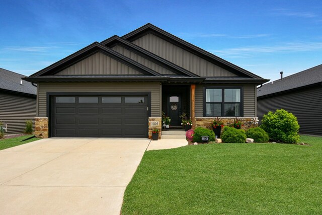 1104 Hershey Rd, Normal, IL 61761 - craftsman-style house featuring concrete driveway, a front yard, an attached garage, board and batten siding, and stone siding