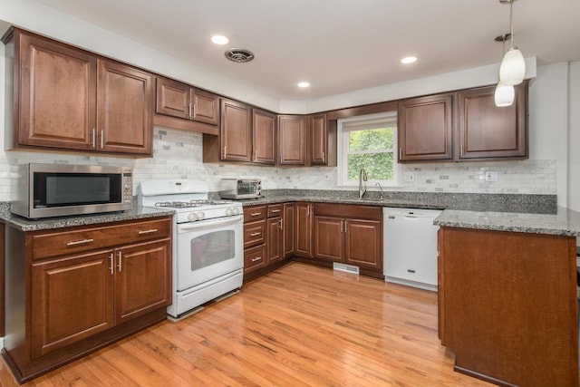 1504 Pfingsten Rd, Glenview, IL 60025 - kitchen with white appliances, light wood-style flooring, dark stone countertops, tasteful backsplash, and decorative light fixtures