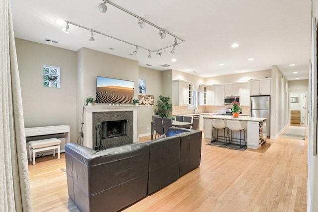 1347 W Washington Blvd Unit 2D, Chicago, IL 60607 - living room featuring light wood finished floors, a fireplace, rail lighting, and recessed lighting
