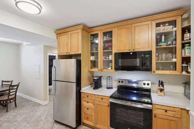 8911 Lamon Ave Unit A, Skokie, IL 60077 - kitchen featuring appliances with stainless steel finishes, light countertops, glass insert cabinets, and light tile patterned floors