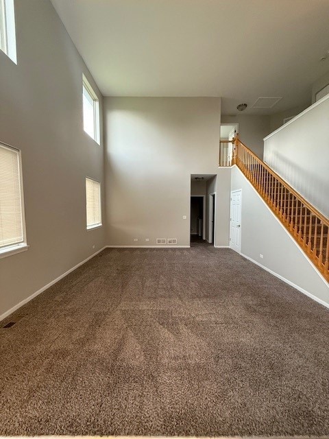8307 Greenbridge Ct, Joliet, IL 60431 - unfurnished living room with a towering ceiling, carpet floors, baseboards, and stairs
