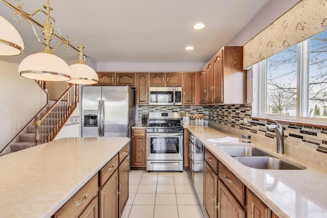 21436 W Larch Ct, Plainfield, IL 60544 - kitchen with stainless steel appliances, a sink, light countertops, decorative backsplash, and brown cabinetry