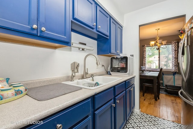 8473 Archer Ave Unit 204, Willow Springs, IL 60480 - kitchen with blue cabinets, a chandelier, and light countertops