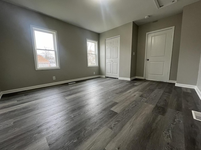 1204 N Park St, Streator, IL 61364 - unfurnished bedroom with dark wood-type flooring, baseboards, and a closet