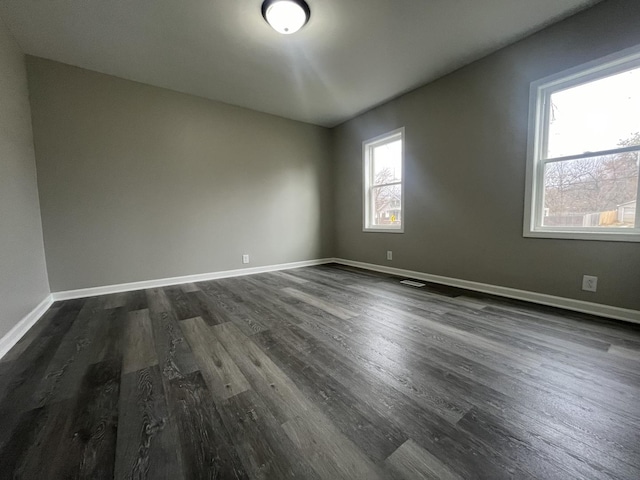 1204 N Park St, Streator, IL 61364 - spare room featuring dark wood-style flooring and baseboards