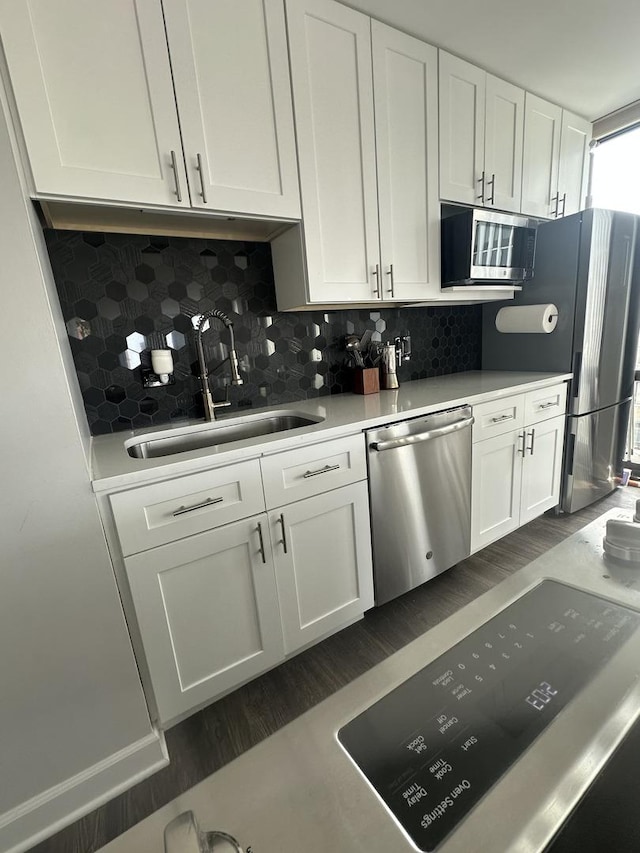 1 E Scott St Unit 1910, Chicago, IL 60610 - kitchen with appliances with stainless steel finishes, dark wood-style floors, white cabinets, backsplash, and light countertops