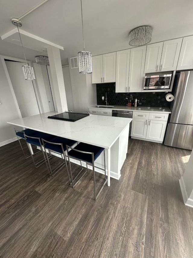 1 E Scott St Unit 1910, Chicago, IL 60610 - kitchen featuring stainless steel appliances, dark wood-type flooring, white cabinets, and tasteful backsplash