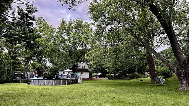 644 Genesee Ave, Morrison, IL 61270 - view of grassy yard featuring a trampoline and an outdoor pool