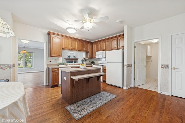 122 Santa Fe Ln, Willow Springs, IL 60480 - kitchen with white appliances, a center island, light countertops, wood finished floors, and ceiling fan