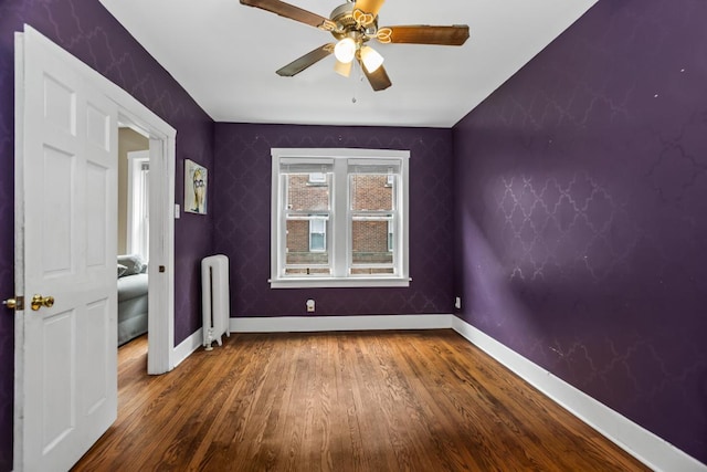 132 Clyde Ave Unit 1, Evanston, IL 60202 - unfurnished bedroom featuring radiator, wood finished floors, and ceiling fan