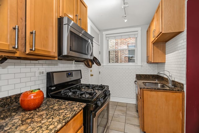 132 Clyde Ave Unit 1, Evanston, IL 60202 - kitchen with stainless steel appliances, dark stone countertops, brown cabinets, and decorative backsplash