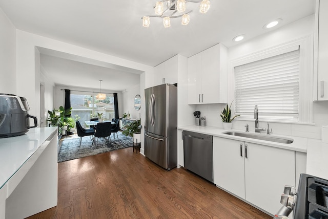 3647 N Nordica Ave, Chicago, IL 60634 - kitchen with stainless steel appliances, a chandelier, a sink, white cabinets, and recessed lighting