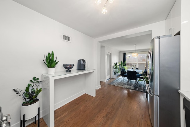 3647 N Nordica Ave, Chicago, IL 60634 - kitchen featuring freestanding refrigerator, light countertops, dark wood-style flooring, a chandelier, and white cabinetry