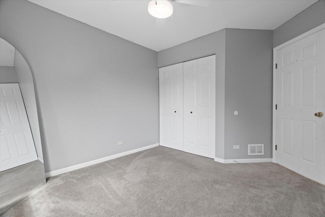 232 Lexington Ct, Grayslake, IL 60030 - unfurnished bedroom featuring carpet flooring, a closet, arched walkways, and a ceiling fan