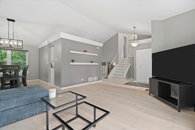 232 Lexington Ct, Grayslake, IL 60030 - living room featuring lofted ceiling, stairs, a chandelier, and light wood-type flooring
