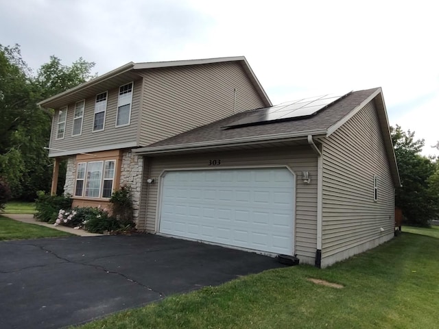 303 Lamplighter Loop, Poplar Grove, IL 61065 - view of home's exterior with asphalt driveway, solar panels, an attached garage, a lawn, and stone siding