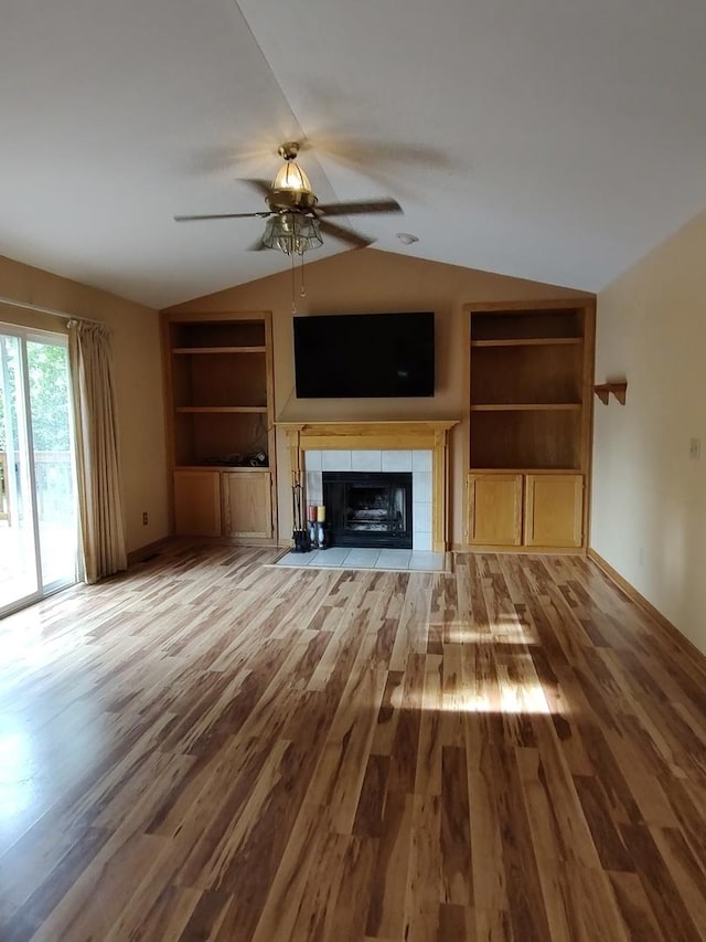 303 Lamplighter Loop, Poplar Grove, IL 61065 - unfurnished living room featuring ceiling fan, built in features, lofted ceiling, wood finished floors, and a tile fireplace