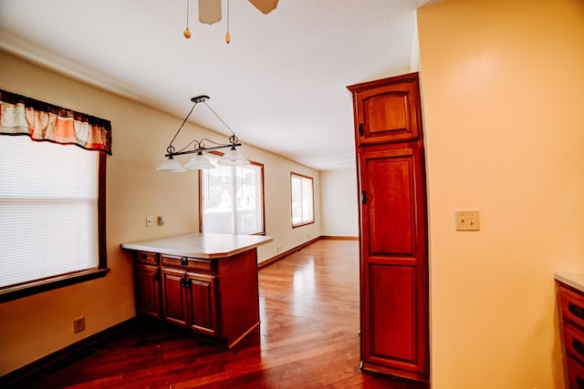 538 E Mulberry St, Watseka, IL 60970 - kitchen with a peninsula, dark wood-type flooring, a ceiling fan, light countertops, and dark brown cabinets