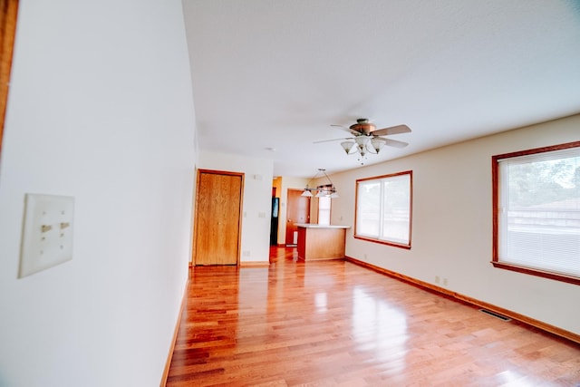 538 E Mulberry St, Watseka, IL 60970 - unfurnished living room with light wood finished floors, a ceiling fan, and baseboards