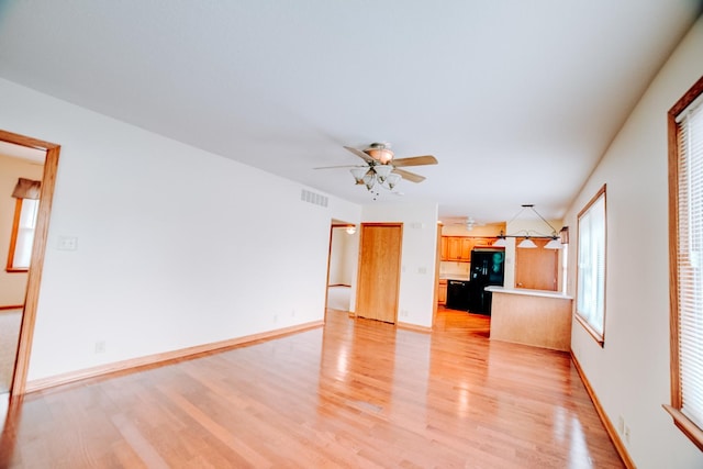 538 E Mulberry St, Watseka, IL 60970 - unfurnished living room with light wood-type flooring, a ceiling fan, and baseboards