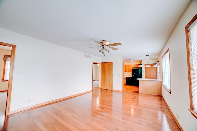 538 E Mulberry St, Watseka, IL 60970 - unfurnished living room featuring light wood finished floors, ceiling fan, and baseboards