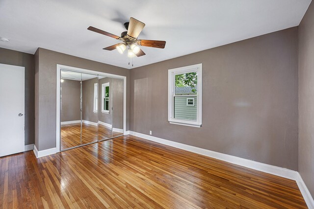 1005 N Walnut St, Normal, IL 61761 - unfurnished bedroom with hardwood / wood-style flooring, a closet, and ceiling fan