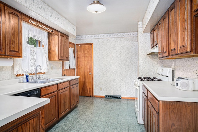 6291 Fallen Timbers Ave, Portage, IN 46368 - kitchen featuring white range with gas stovetop, a sink, under cabinet range hood, brown cabinets, and wallpapered walls