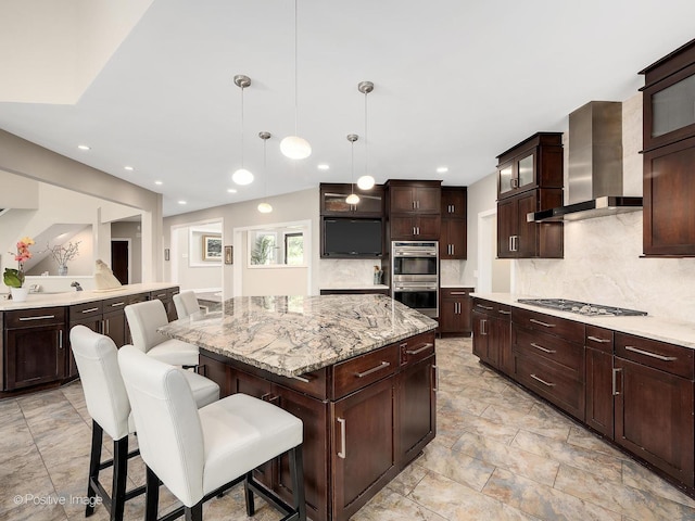 28W535 Purnell Rd, West Chicago, IL 60185 - kitchen featuring wall chimney range hood, double oven, decorative backsplash, a kitchen island, and a breakfast bar