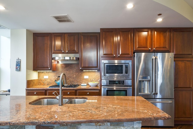 910 S Michigan Ave Unit 1411, Chicago, IL 60605 - kitchen featuring stainless steel appliances, under cabinet range hood, stone counters, backsplash, and arched walkways