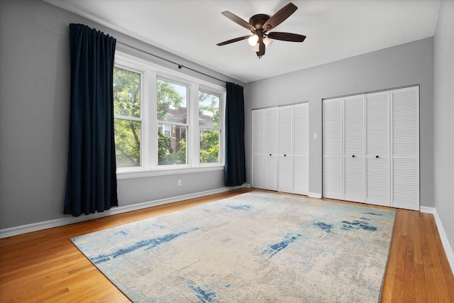 5000 N Glenwood Ave Unit 2, Chicago, IL 60640 - unfurnished bedroom with two closets, wood finished floors, and a ceiling fan