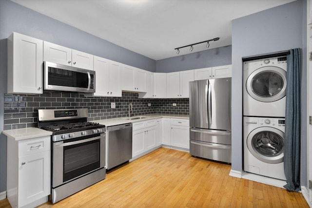 5000 N Glenwood Ave Unit 2, Chicago, IL 60640 - kitchen featuring stainless steel appliances, stacked washing machine and dryer, light countertops, and white cabinets