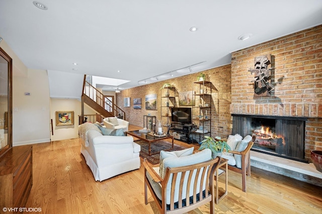 1728 Wildberry Dr Unit B, Glenview, IL 60025 - living area featuring track lighting, a brick fireplace, wood finished floors, stairway, and brick wall