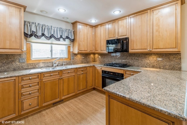 579 Figard Ln, Des Plaines, IL 60016 - kitchen with black appliances, light stone counters, and light wood-type flooring