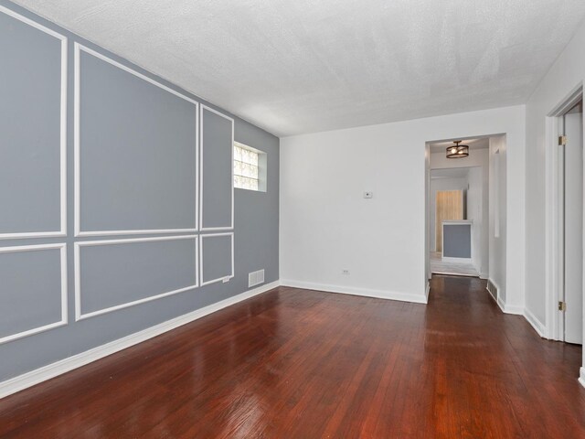 142 W Brayton St, Chicago, IL 60628 - unfurnished room with hardwood / wood-style flooring, baseboards, and a textured ceiling