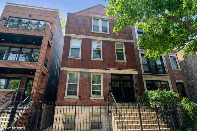 1020 N Wood St, Chicago, IL 60622 - multi unit property featuring brick siding, a fenced front yard, and a balcony