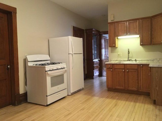1020 N Wood St, Chicago, IL 60622 - kitchen with white appliances, light wood-style flooring, and brown cabinetry