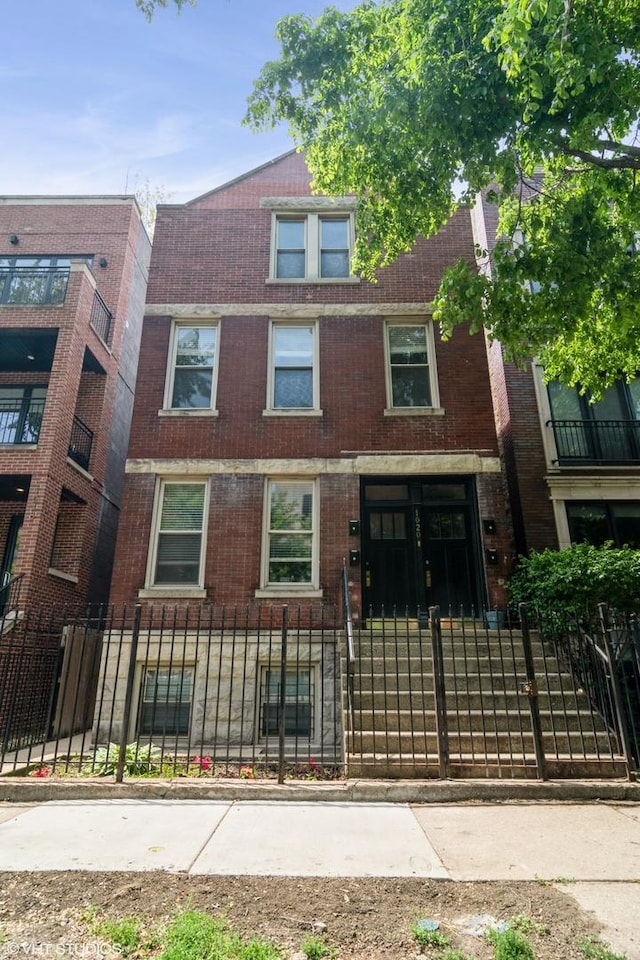 1020 N Wood St, Chicago, IL 60622 - townhome / multi-family property with a fenced front yard and brick siding