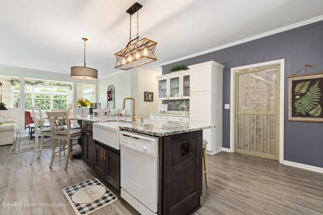 17228 Fontana Ln, Lockport, IL 60441 - kitchen with dishwasher, light wood-type flooring, an island with sink, glass insert cabinets, and crown molding