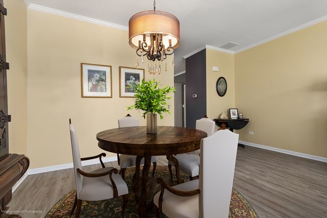 17228 Fontana Ln, Lockport, IL 60441 - dining space with wood finished floors, crown molding, and a chandelier
