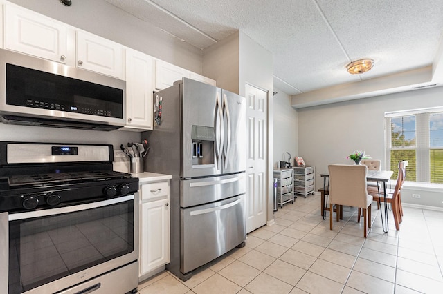 390 W Mahogany Ct Unit 301, Palatine, IL 60067 - kitchen featuring appliances with stainless steel finishes, white cabinets, light tile patterned flooring, a textured ceiling, and light countertops