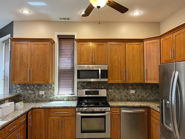 5722 S Aberdeen St, Chicago, IL 60621 - kitchen featuring stainless steel appliances, brown cabinets, ceiling fan, and tasteful backsplash