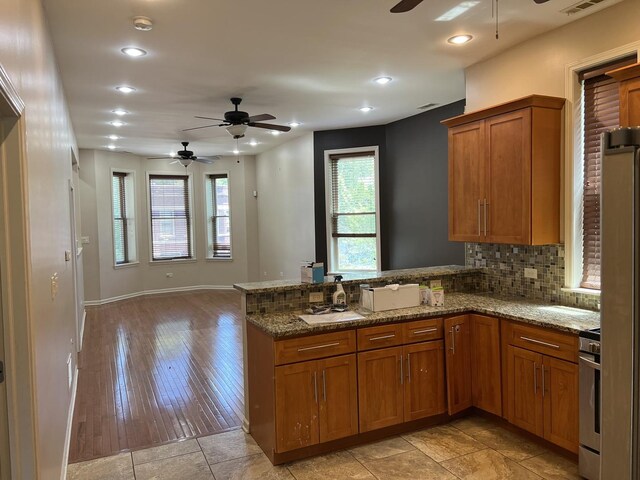 5722 S Aberdeen St, Chicago, IL 60621 - kitchen with ceiling fan, brown cabinetry, a peninsula, stone counters, and recessed lighting