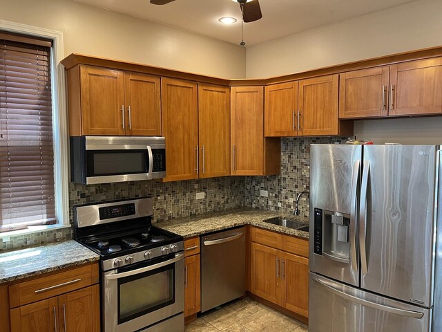 5722 S Aberdeen St, Chicago, IL 60621 - kitchen with stainless steel appliances, brown cabinetry, and backsplash