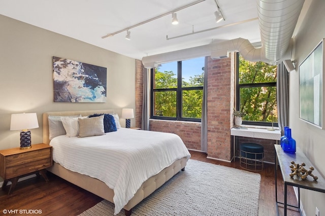 520 W Huron St Unit 220, Chicago, IL 60654 - bedroom featuring track lighting, wood finished floors, and brick wall
