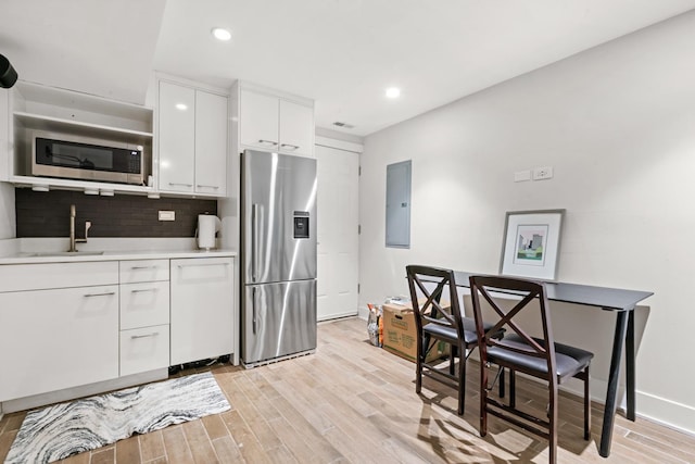 2113 N Clark St, Chicago, IL 60614 - kitchen featuring stainless steel appliances, a sink, electric panel, light wood-style flooring, and recessed lighting